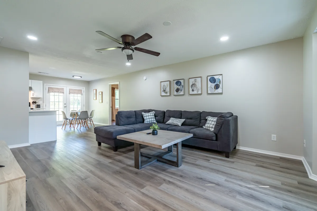 Open-plan living room with French doors and hardwood floors